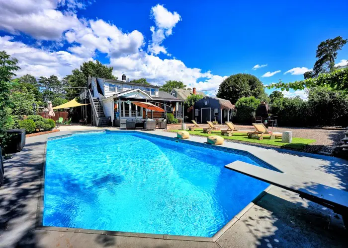 A luxury pool with clear blue water overlooking the garden villa